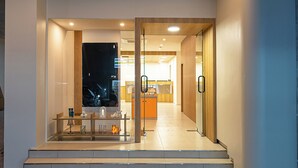 A modern hotel lobby with a reception desk, a staircase leading to the upper floor, and a view of the interior. - Anook Hotel Daejeon Yongjeon Ⅱ (Daejeon)