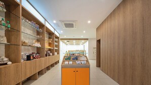 A modern retail space with wooden shelving, a central display unit, and a clean, tiled floor. - Anook Hotel Daejeon Yongjeon Ⅱ (Daejeon)