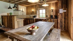 Eine rustikale Küche mit Holzwänden und einem großen Holztisch.