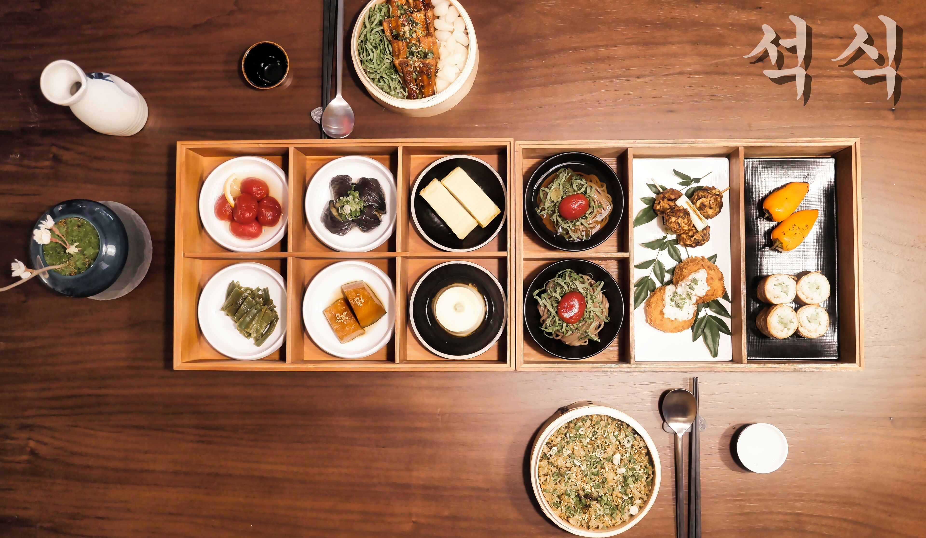 A wooden dining table with various dishes arranged in a traditional Korean style.