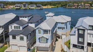 Een woonwijk met huizen aan een meer, met een mix van moderne en traditionele architectuur, een helder uitzicht op het water en een verzorgd gazon.