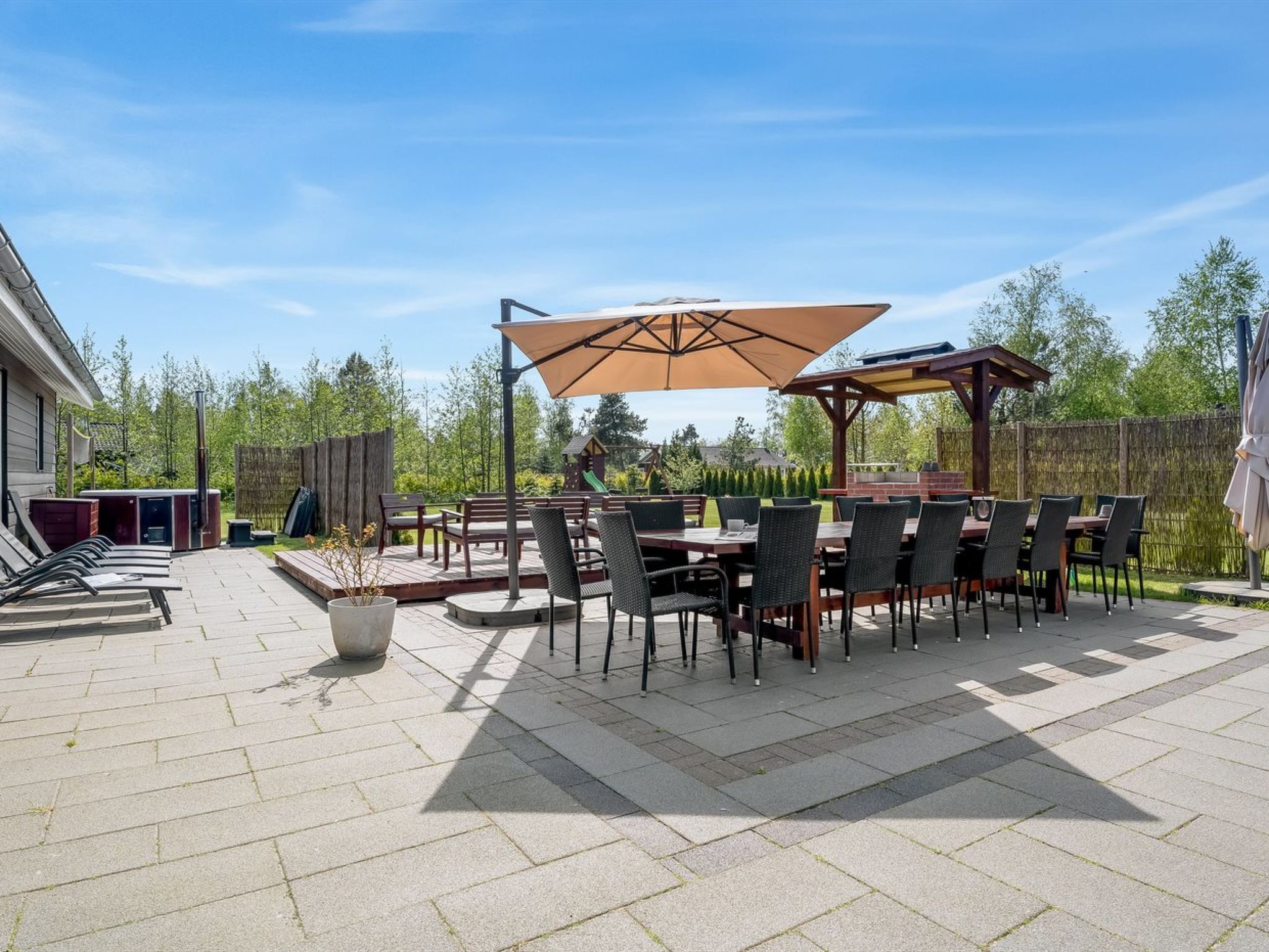Eine Terrassenausstattung im Freien mit Essbereich, Whirlpool und Holz-Pergola.