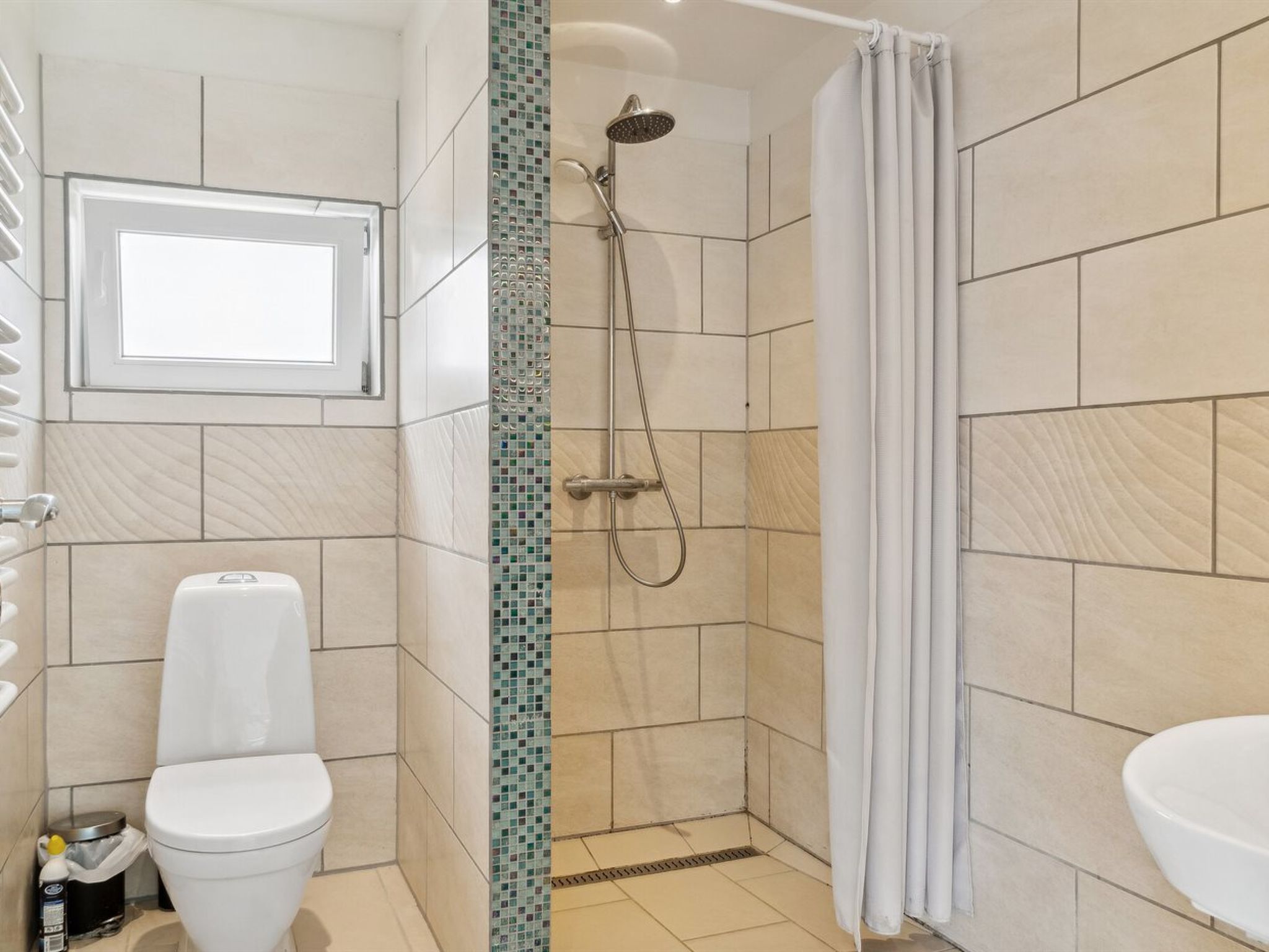 A bathroom with a shower, toilet, and sink.