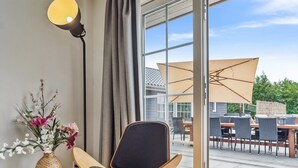 Ein modernes Zimmer mit einer großen Schiebeglasdoor, die auf eine Außenpatio führt.
