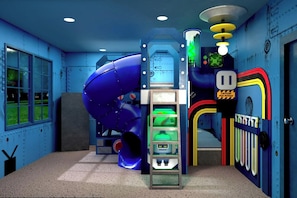 A room with a large blue play structure, a slide, and a door with colorful handles. - Vor5604aa: 5 Bed, Cartoon Lab, Pool (Orlando)