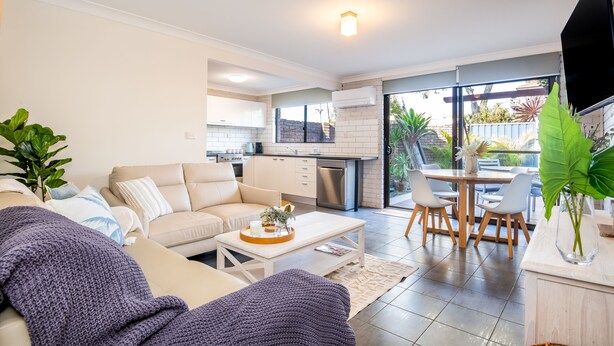 A modern living room with a sofa, coffee table, and a dining area with chairs and a table. - Seadream on Nelson. New listing.
Pet friendly , 300m stroll to beach and cafes.  (Woolgoolga)