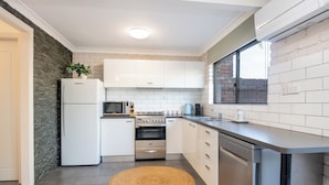 A modern kitchen with white cabinets, a built-in oven, a microwave, and a dishwasher. - Seadream on Nelson. New listing.
Pet friendly , 300m stroll to beach and cafes.  (Woolgoolga)