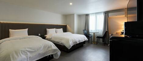 A hotel room with two beds, a desk, a chair, a TV, and a window with curtains.