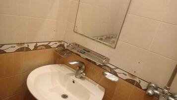 A bathroom with a white sink, a mirror, and a towel rack.