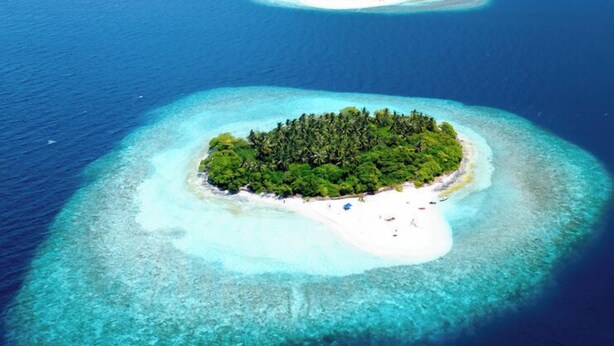 An aerial view of a chain of islands with clear turquoise waters and lush green vegetation. - Dhoani Maldives Guesthouse (Kendhoo)