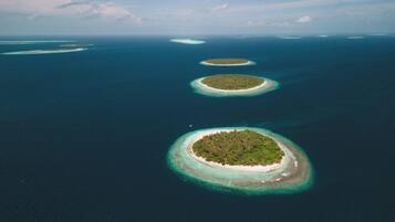 An aerial view of a chain of islands with clear blue waters and a clear sky.