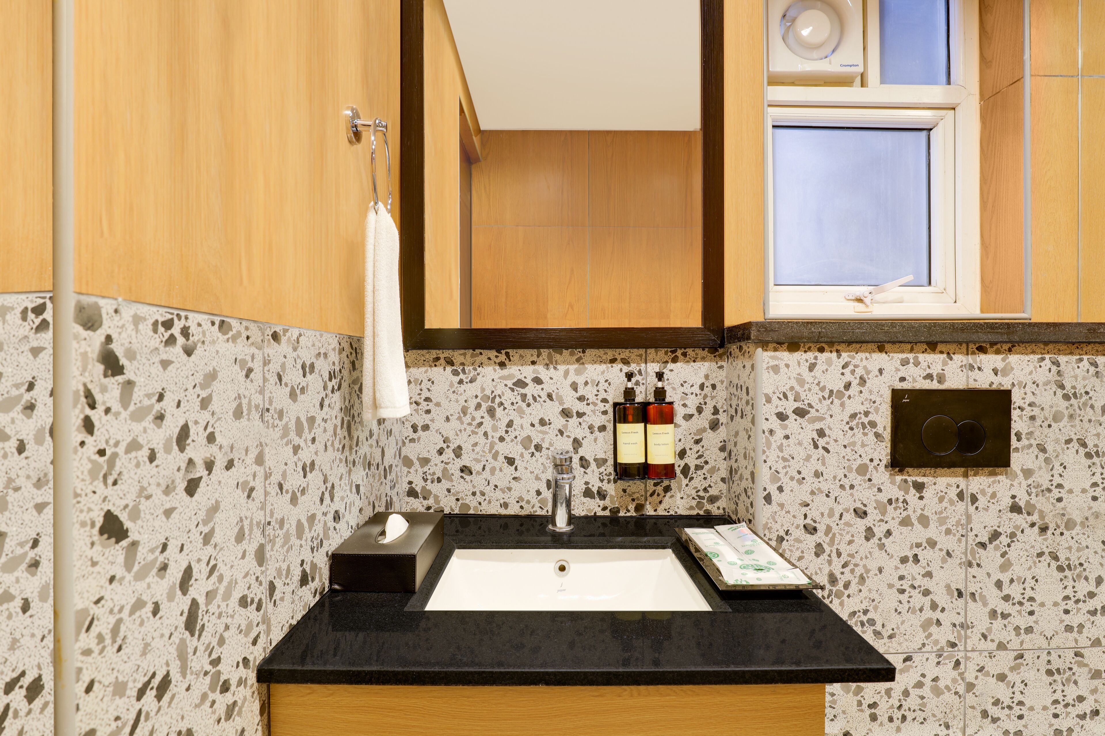 A bathroom with a sink, mirror, towel rack, and toiletries.