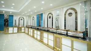 A spacious hotel lobby with a long reception desk, mirrored walls, and a tiled floor. - Golden Hut Derabassi (Dera Bassi)