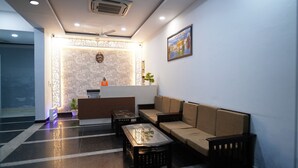 A reception area with a reception desk, sofa, and coffee table. - Golden Hut Derabassi (Dera Bassi)