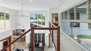 A spacious interior with a high ceiling, a staircase, and a view of the outdoors. - This stunning home is located in Palm Cove. Short 5min walk to the beach. (Palm Cove)