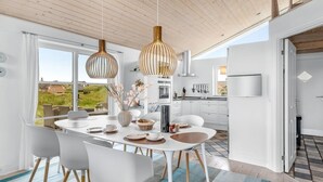 A modern kitchen with white cabinets, a built-in oven, and a large window. - "Elfi" - 700m from the sea by Interhome (Ringkøbing)