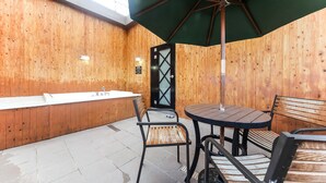 Un interior de madera con una bañera, una mesa y sillas.