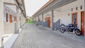 Un pati empedrat amb una moto aparcada a la dreta.