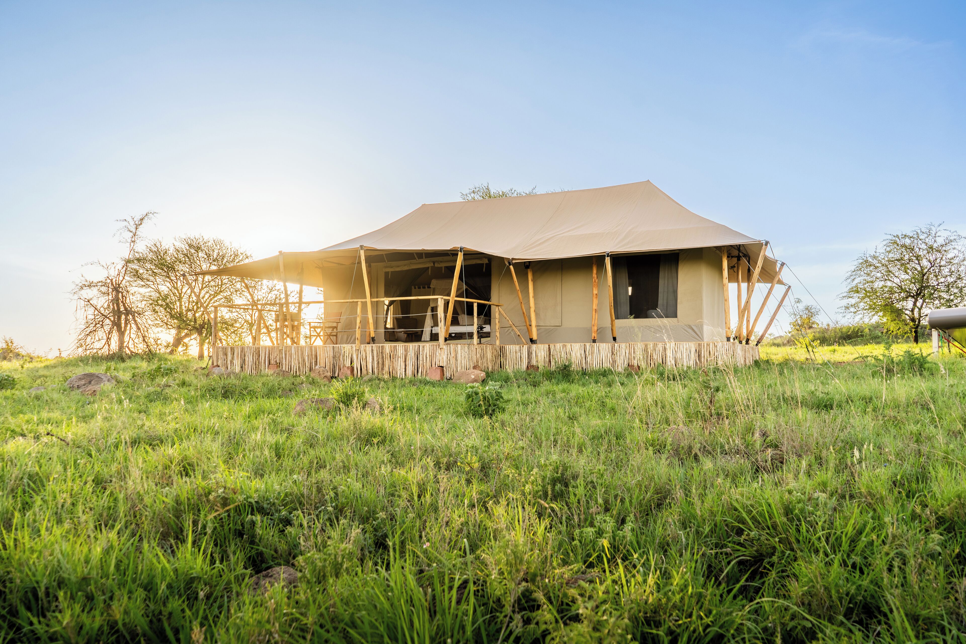 A tent-like structure with a simple, open design, surrounded by a grassy field.