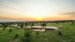 A safari lodge with multiple tents and a clear view of the sunset over a grassy landscape. - Malaika Luxury Camp Seronera Serengeti (Serengeti)
