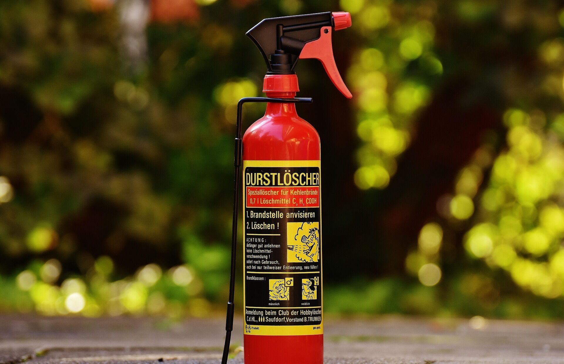A red fire extinguisher with a black nozzle and a yellow label.