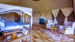 A tented accommodation with a bed, a sofa, and a small table. - Malaika Luxury Camp Seronera Serengeti (Serengeti)