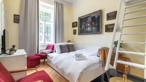 A modern bedroom with a bed, a desk, a chair, and a window with curtains. - Historic Apartment close to Ludmila Cathedral by EasyBNB Premium (Prague)