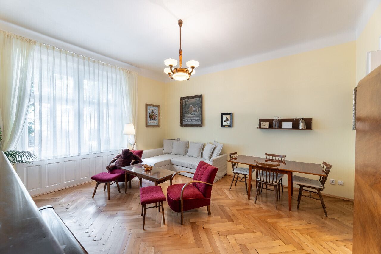 Ein Wohnzimmer mit einer Couch, Sesseln, einem Couchtisch und einem Esstisch.