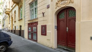 A street view with a building featuring a red door and a sign with the number 1538. - Historic Apartment close to Ludmila Cathedral by EasyBNB Premium (Prague)