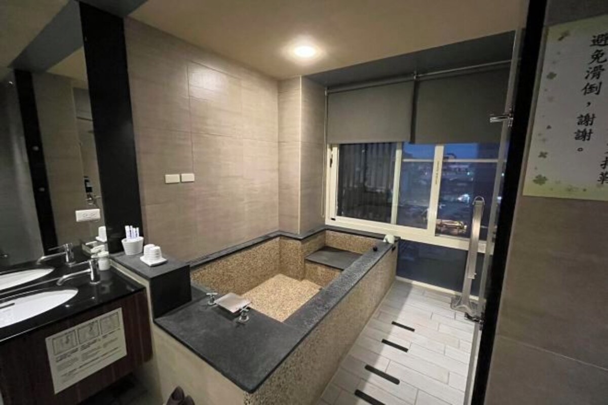 Casa de banho moderna com duas lavatórios, banheira e janela.