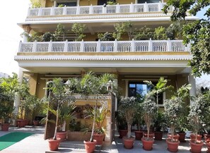 A multi-story building with balconies, potted plants, and a covered entrance. - Jeenmount Heritage Boutique Hotel (Jaipur)