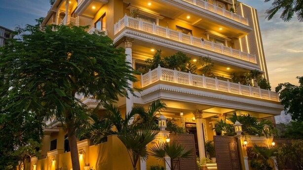 A multi-story hotel with balconies, a gated entrance, and surrounding greenery. - Jeenmount Heritage Boutique Hotel-JLN Marg (Jaipur)