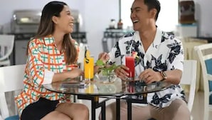 Two people sitting at a round glass table with drinks, in a room with white furniture and a kitchen in the background. - D'Arcici Hotel Sunter (Jakarta)