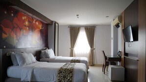A hotel room with two beds, a desk, a chair, a television, and a large window with curtains. - D'Arcici Hotel Sunter (Jakarta)