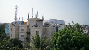 A modern building with multiple antennas and satellite dishes, surrounded by lush greenery and other buildings. - D'Arcici Hotel Sunter (Jakarta)