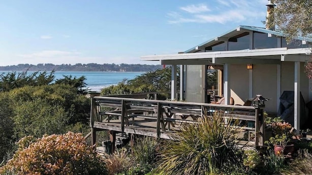 A modern house with a deck overlooking a coastal area. - Captain John's Hideaway (Stinson Beach)
