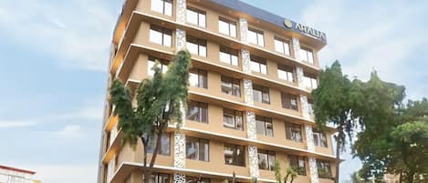 A multi-story hotel with a modern design, featuring balconies and large windows.