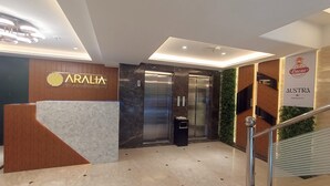 A modern hotel lobby with a reception desk, a staircase, and an elevator. - Aralia International Airport Mumbai (Mumbai)