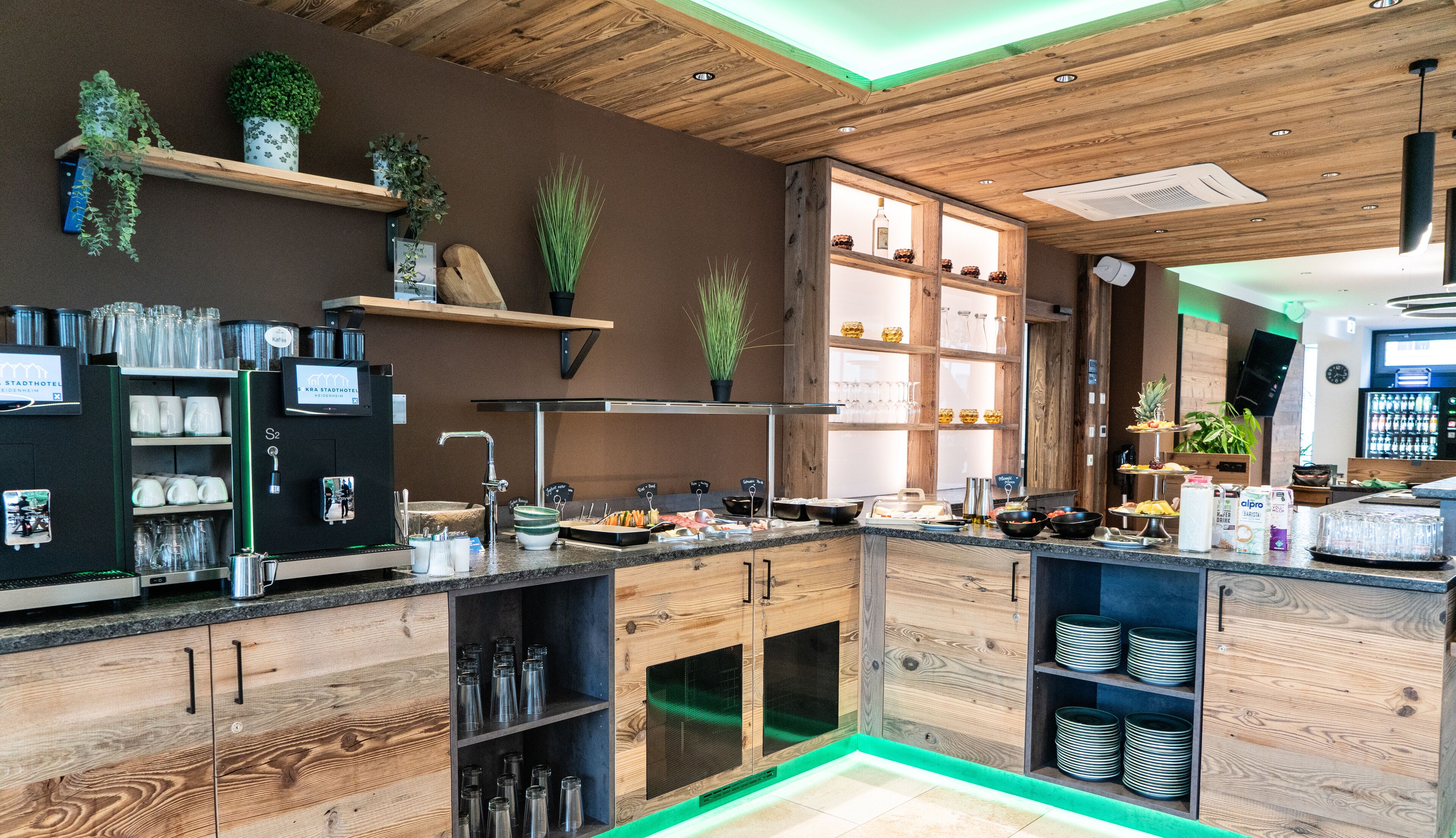 A modern kitchen with wooden cabinets, a coffee machine, and various kitchen utensils.