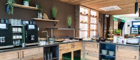 A modern kitchen with wooden cabinets, a coffee machine, and various kitchen utensils.