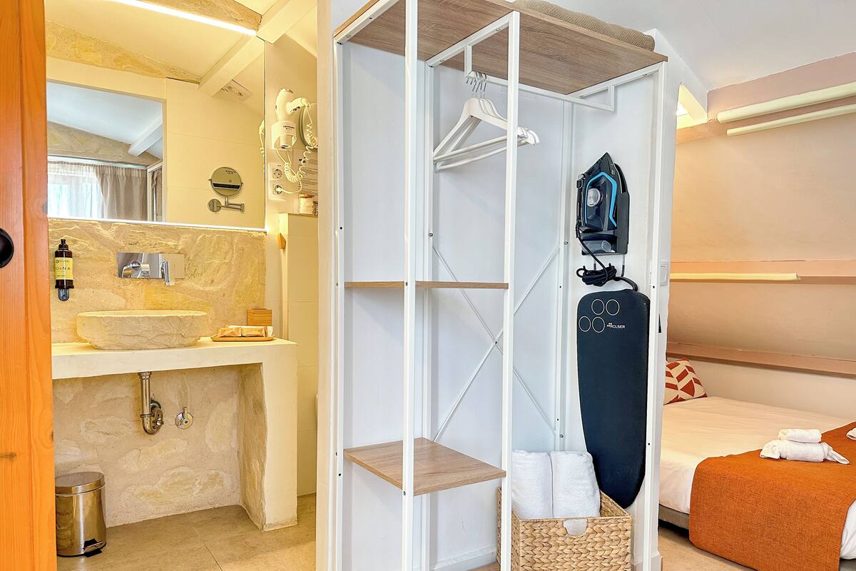 Una habitación de hotel moderna con baño, armario y cama.