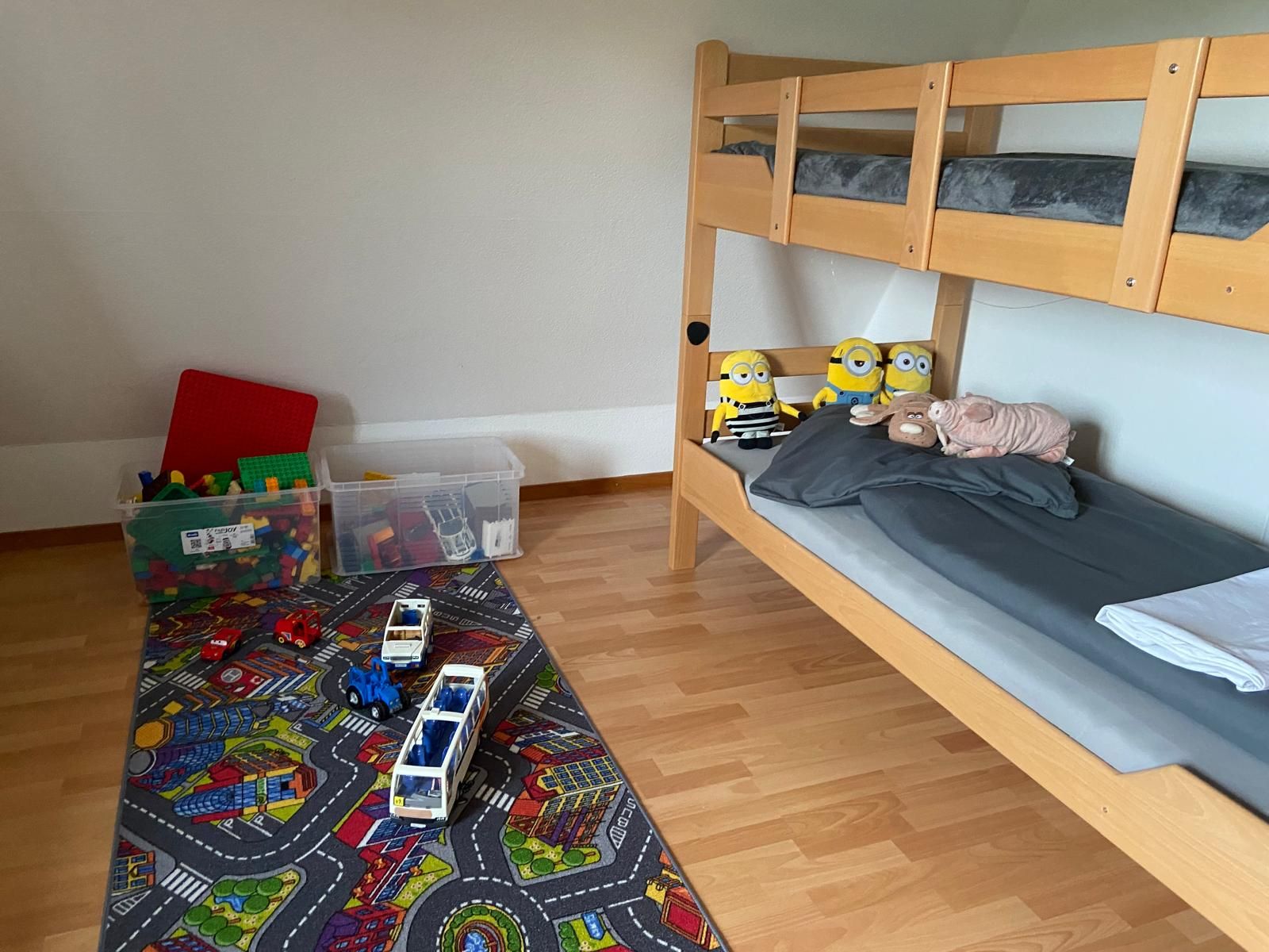 Ein Etagenbett mit Stauraum und einer Spielecke mit Spielzeugautos.
