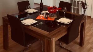 Ein Essbereich mit einer Kronleuchter, einem Holztisch und Stühlen.