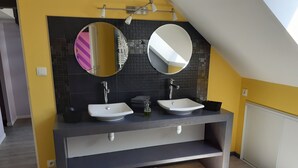 A modern bathroom with two sinks, a dark tiled backsplash, and a skylight. - Le Toit de Charme D'isabelle ! (Beaune)