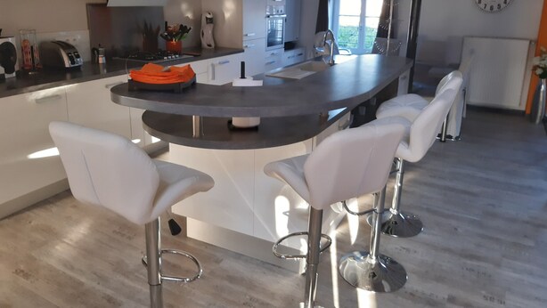 A modern kitchen with a central island, bar stools, and a clock on the wall. - Le Toit de Charme D'isabelle ! (Beaune)
