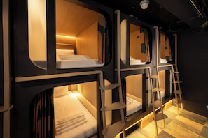 A train-themed hotel room with bunk beds, wooden accents, and a ladder. - Kabannas London St Pancras (London)
