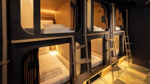 A train-themed hotel room with bunk beds, wooden accents, and a ladder. - Kabannas London St Pancras (London)