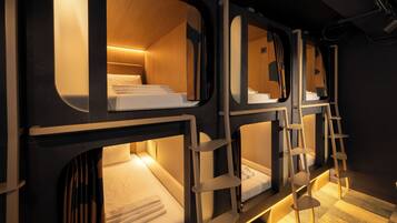 A train-themed hotel room with bunk beds, wooden accents, and a ladder.