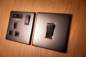 A wall-mounted electrical outlet with four USB ports and a switch. - Kabannas London St Pancras (London)