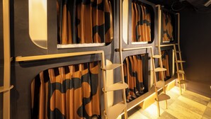 A room with a checkered floor, a bed with a headboard, and a window with curtains. - Kabannas London St Pancras (London)